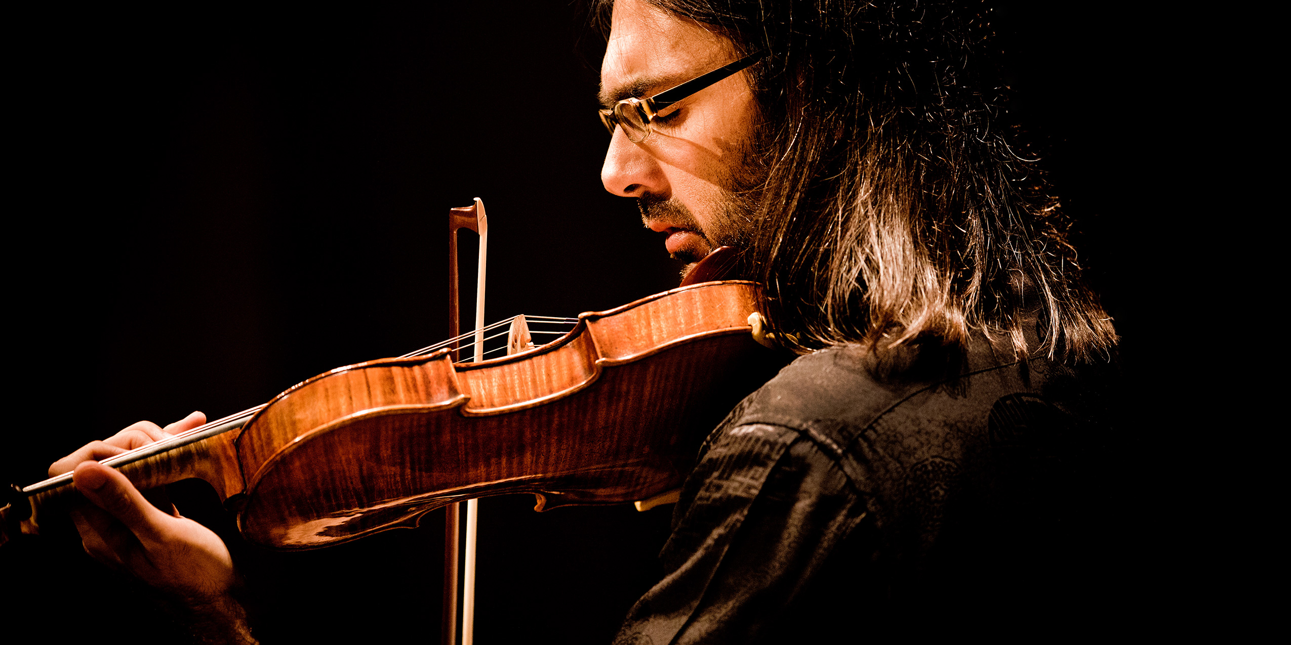Leonidas Kavakos i profil med violin hvilende på kind til koncert i DR Koncerthuset. 