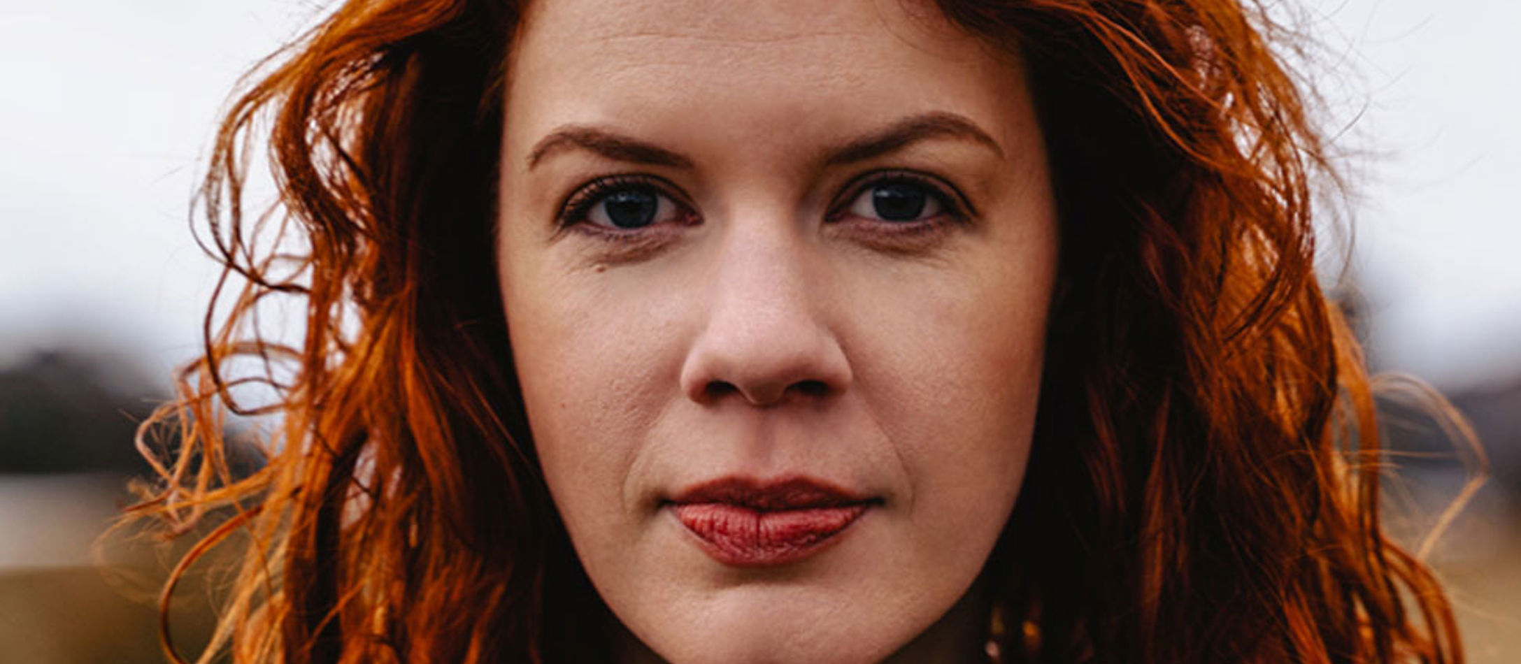 Rødhårede Catriona Morison med røde øjenbryn og røde læber kigger ligefrem