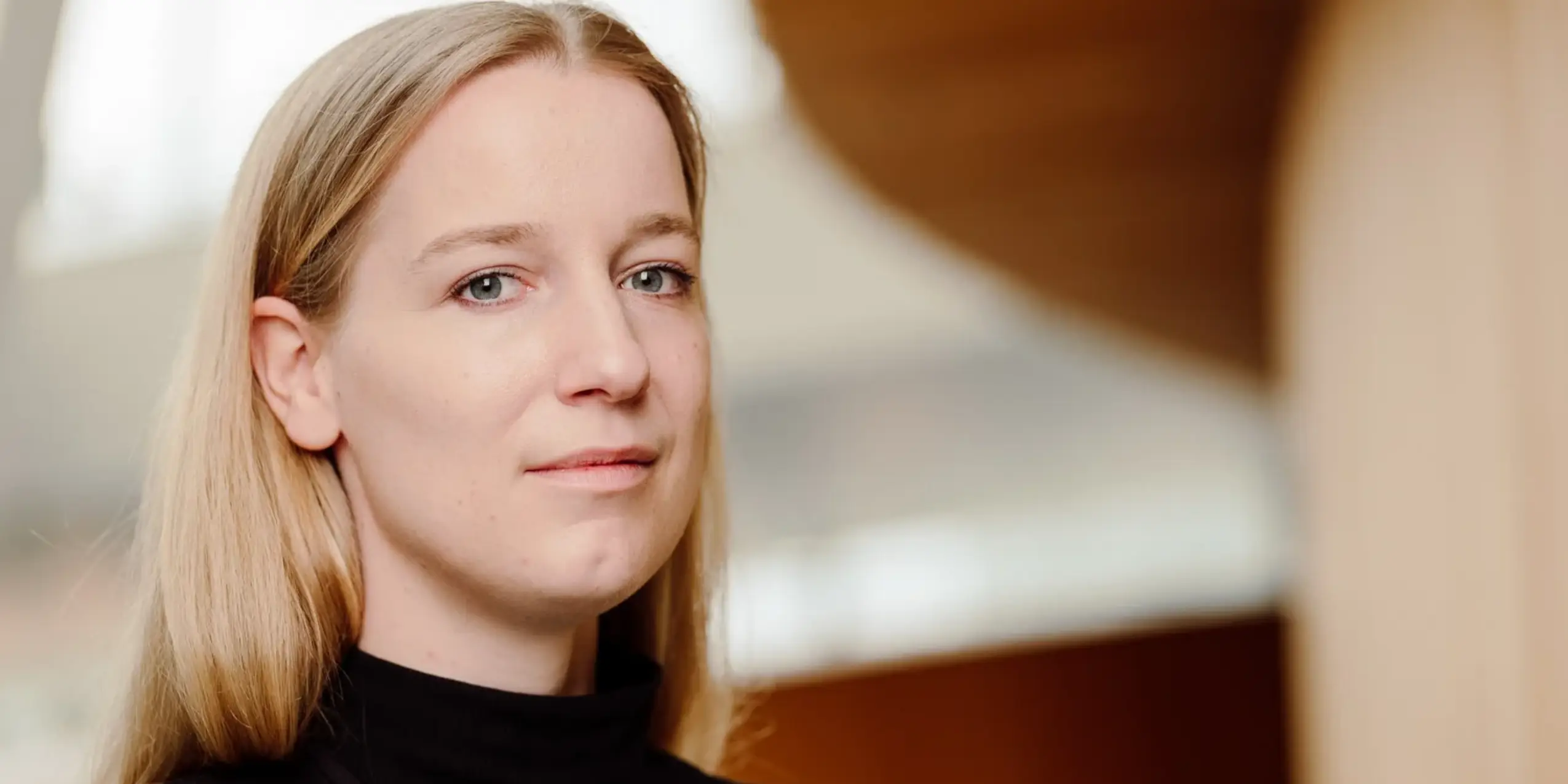 Kvinde i sort kigger ind i kameraet.