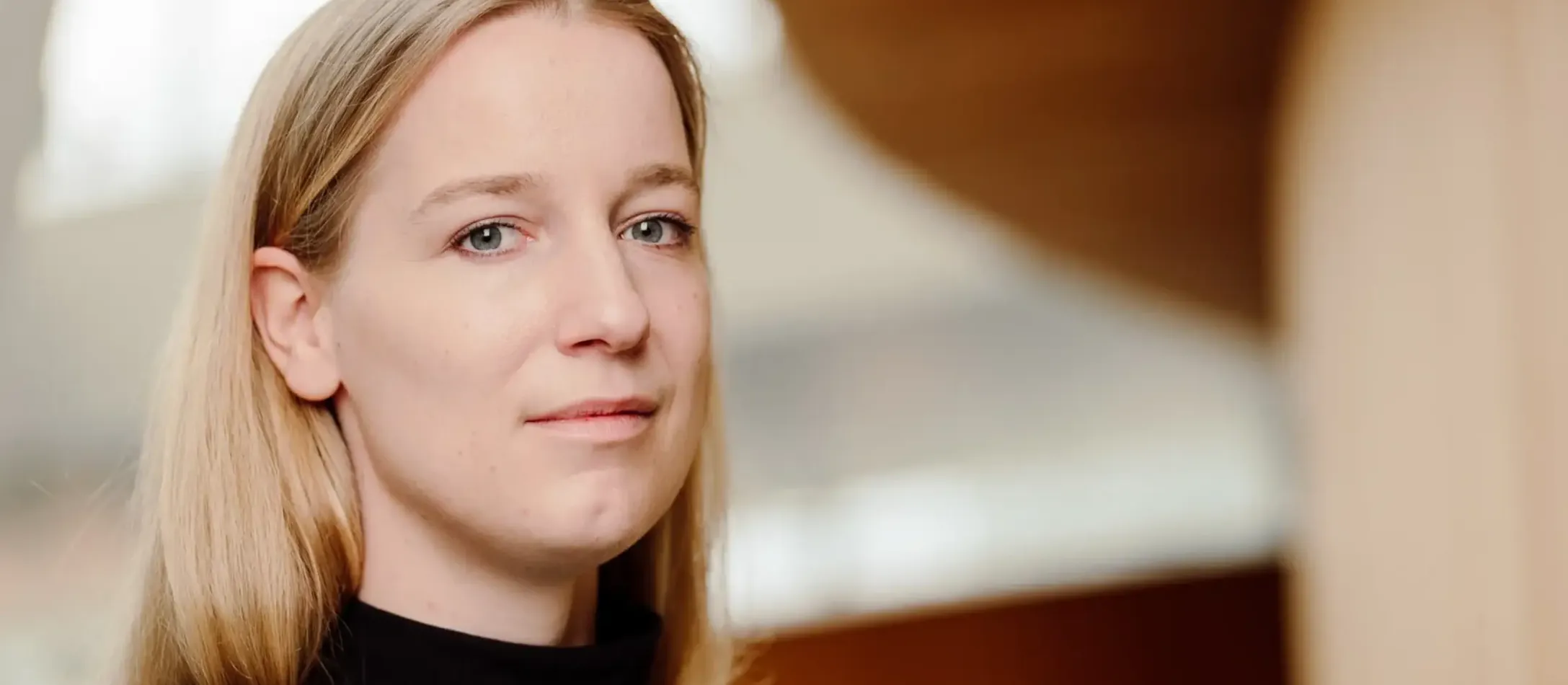 Kvinde i sort kigger ind i kameraet.