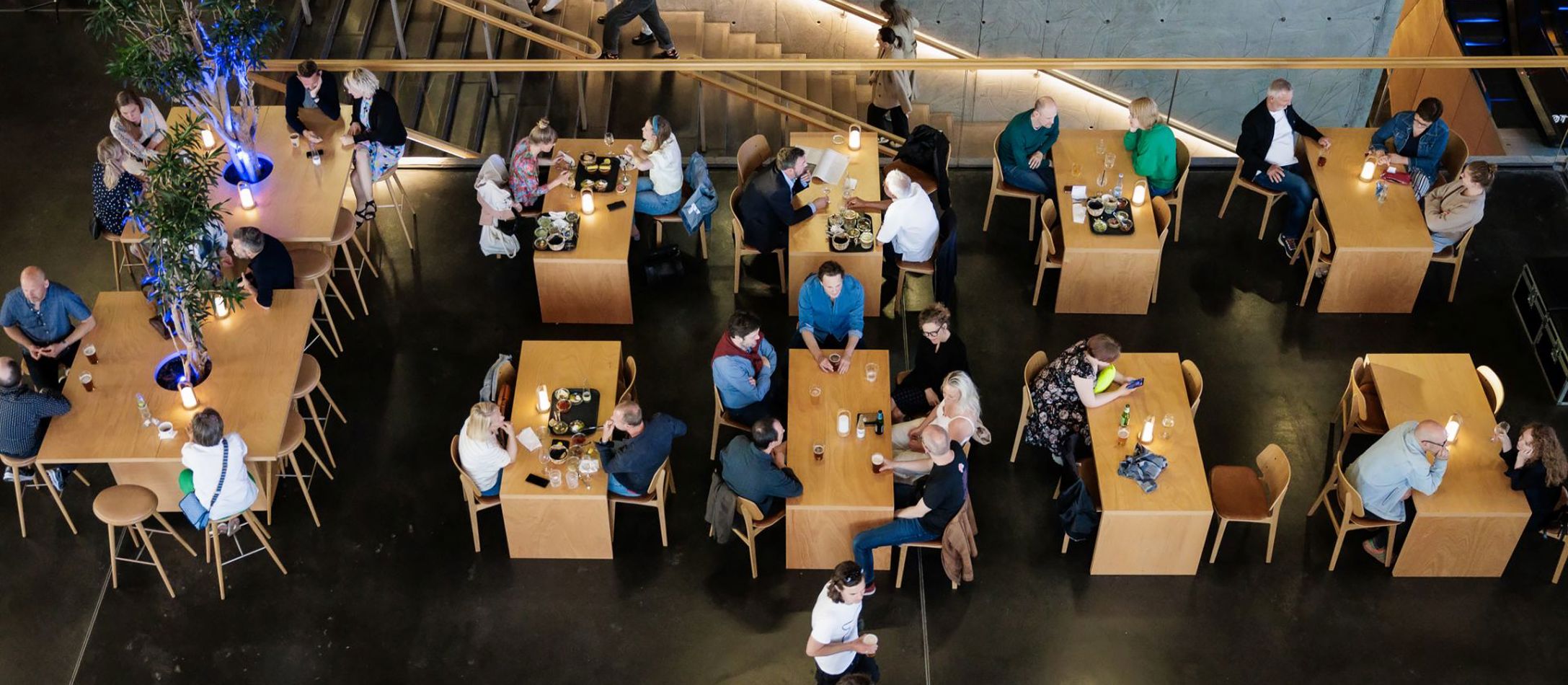 Mennesker nyder et glas i DR Koncerthusets foyer inden koncert set ovenfra.