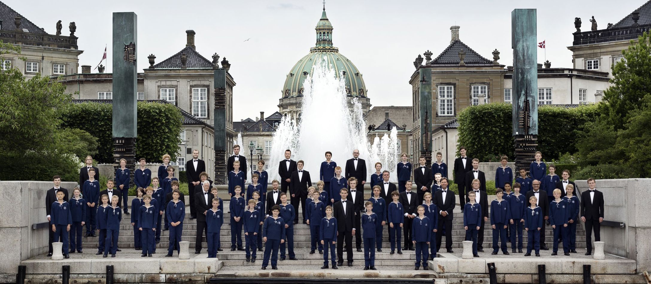 Københavns Drengekor synger foran springvandet med Amalienborg i baggrunden.