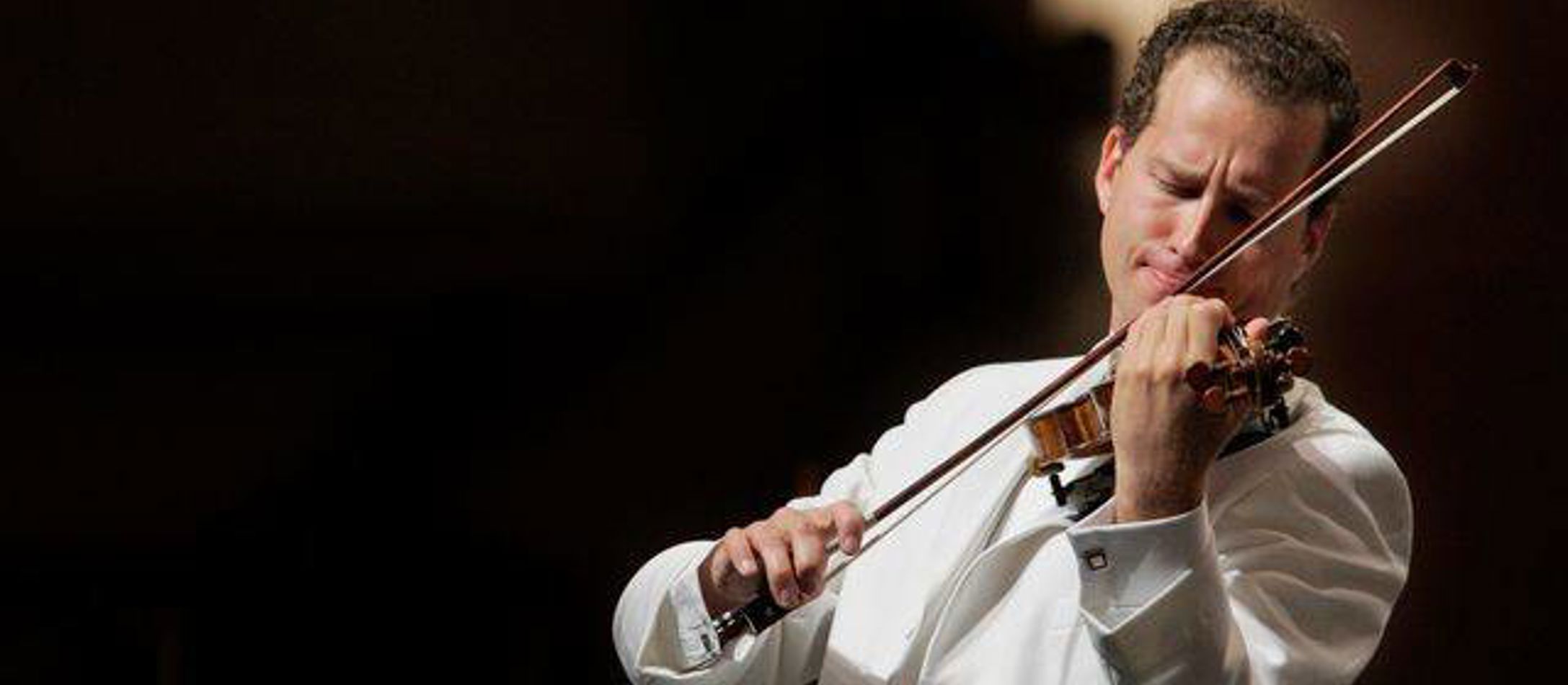 Nikolaj Znaider iført hvidt jakkesæt ifærd med at spille violin