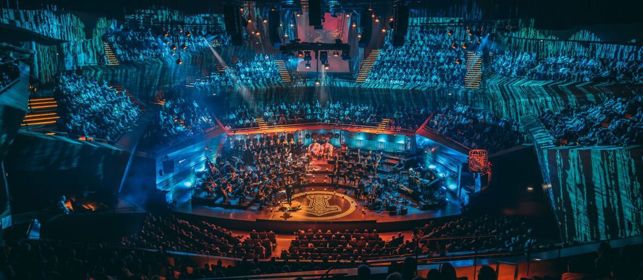 Koncertsalen oplyst i bølgende blå nuancer under koncerten Gaming X Symphony 2024.