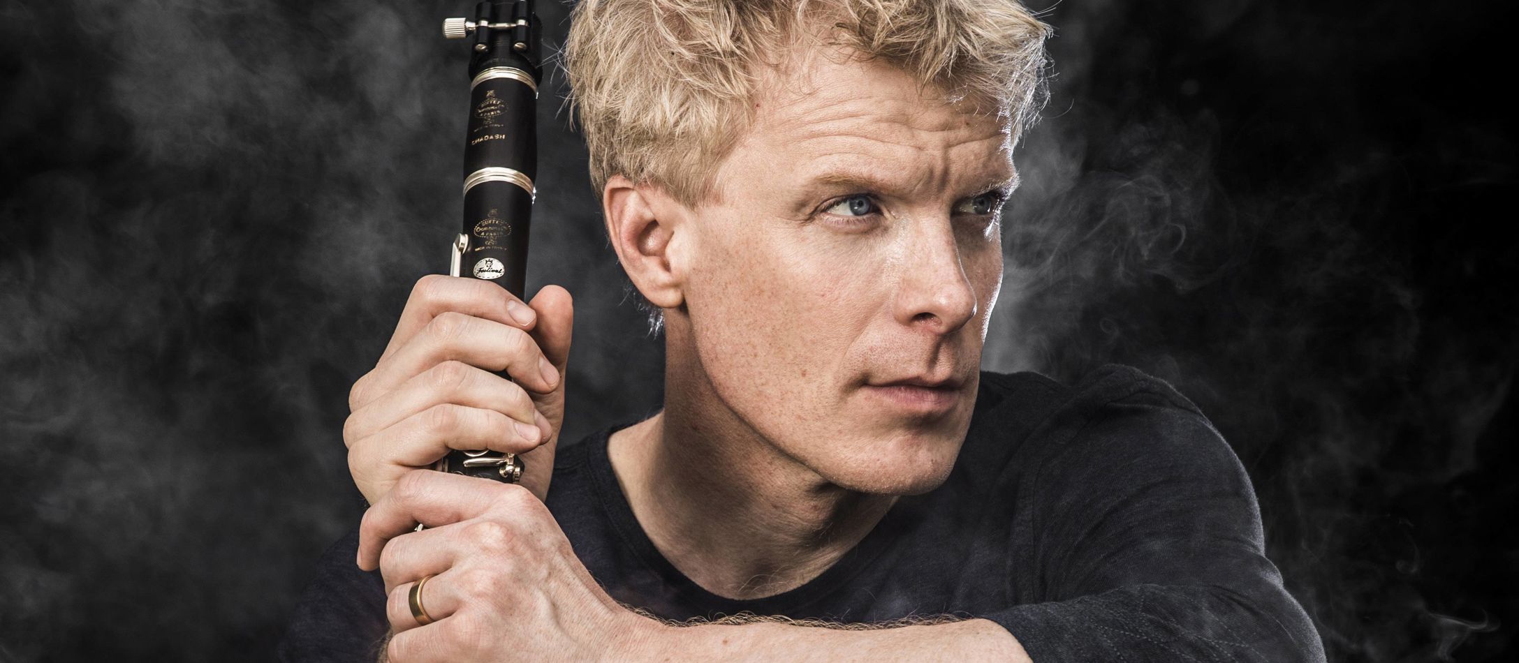 Martin Fröst sidder med klarinet omgivet af let røg