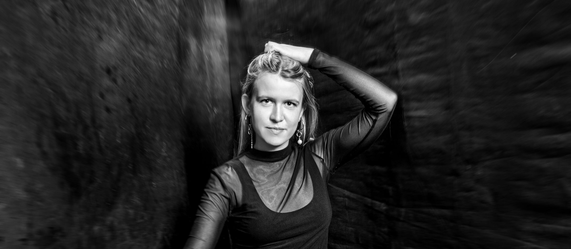 Ragnheiður Ingunn Jóhannsdóttir iklædt sort med sin dirigentstang i højre hånd, der peger nedad og ligner en tryllestav.