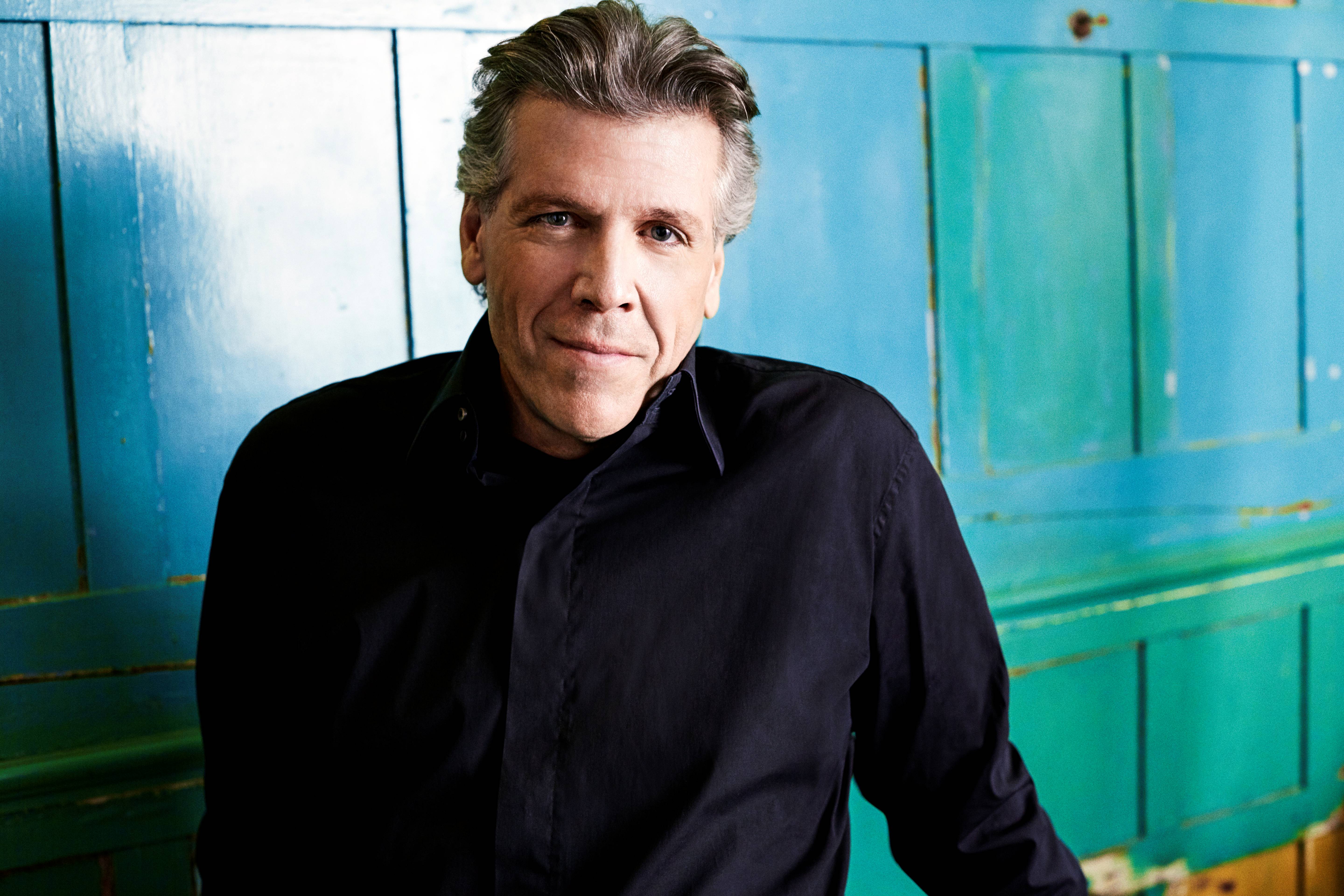 Thomas Hampson iført sort skjorte foran blålig baggrund