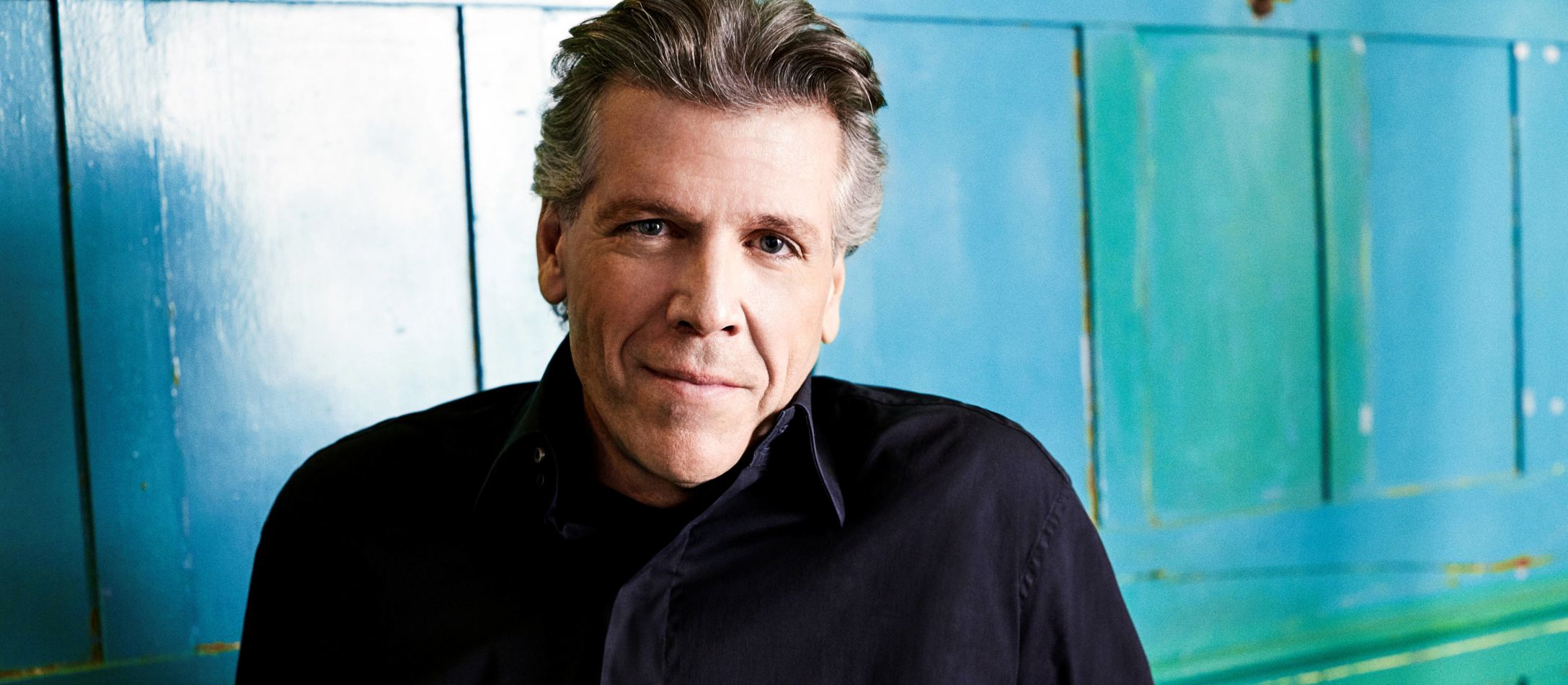 Thomas Hampson iført sort skjorte foran blålig baggrund