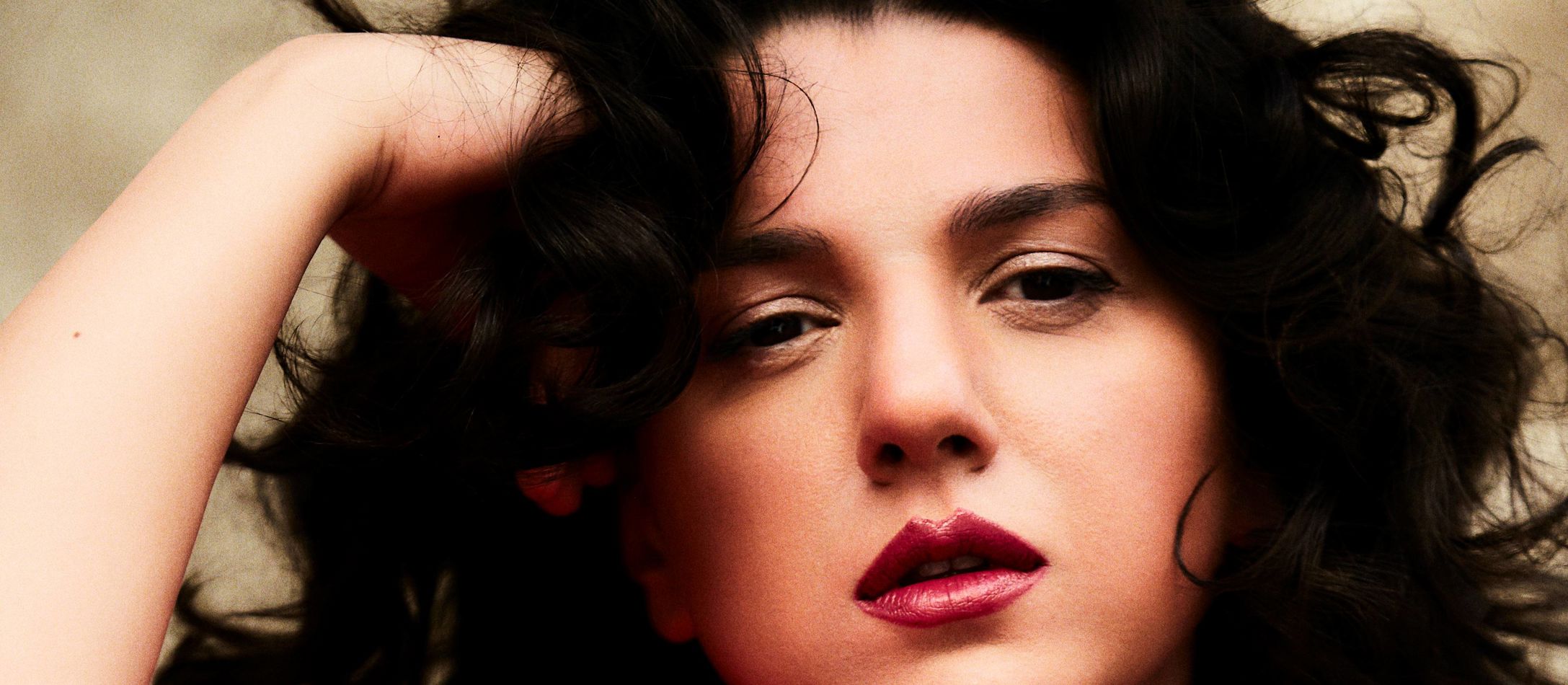 Khatia Buniatishvili med krøllet mørkt hår iført rød silkekjole