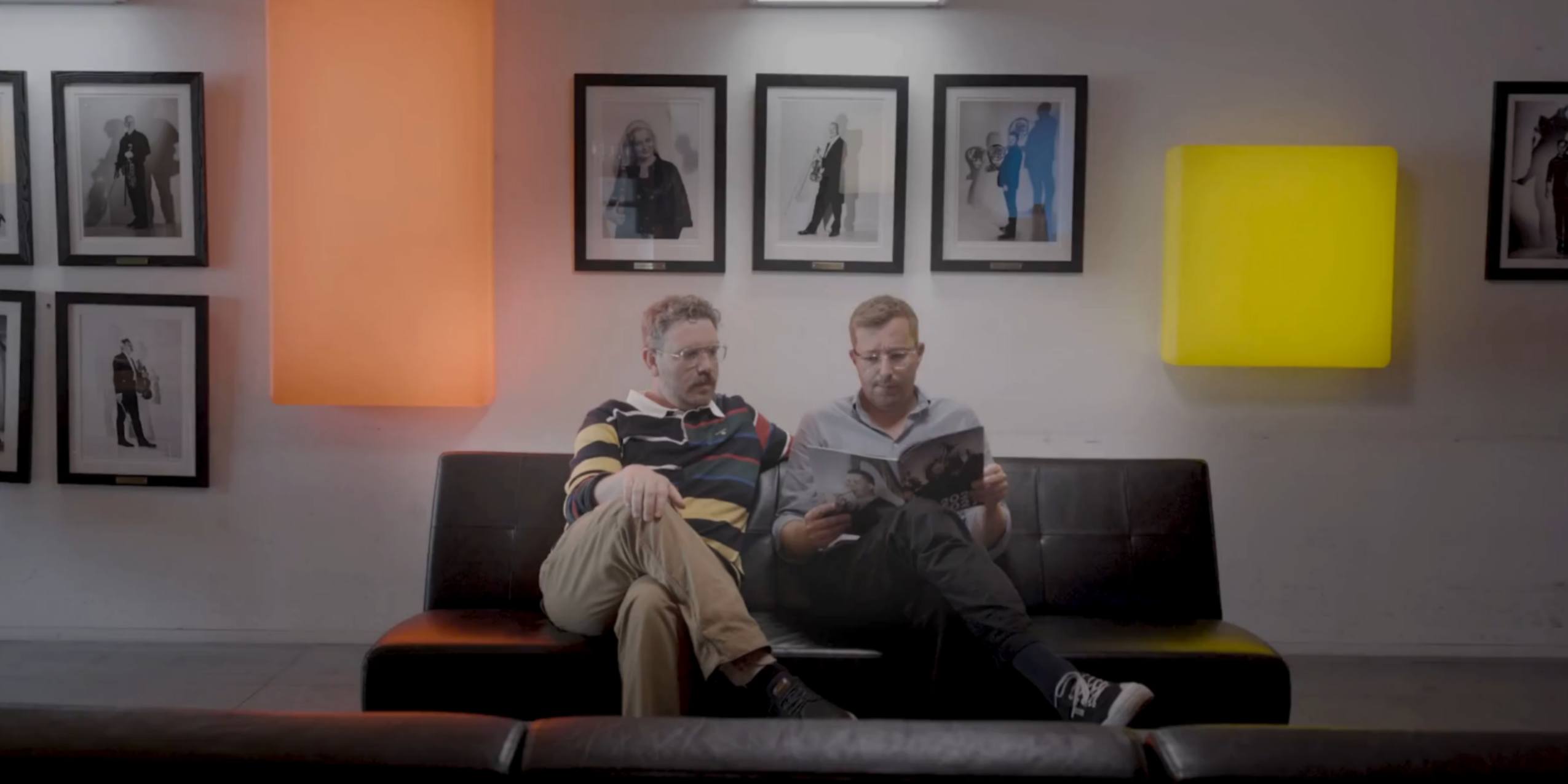 Frederik Cilius og Rasmus Bruun sidder i en sofa og bladrer i DR Symfoniorkestrets sæsonbrochure