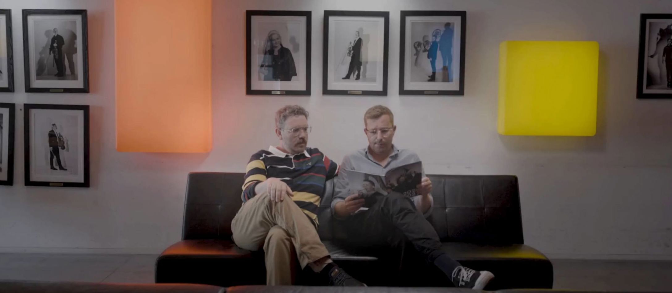 Frederik Cilius og Rasmus Bruun sidder i en sofa og bladrer i DR Symfoniorkestrets sæsonbrochure