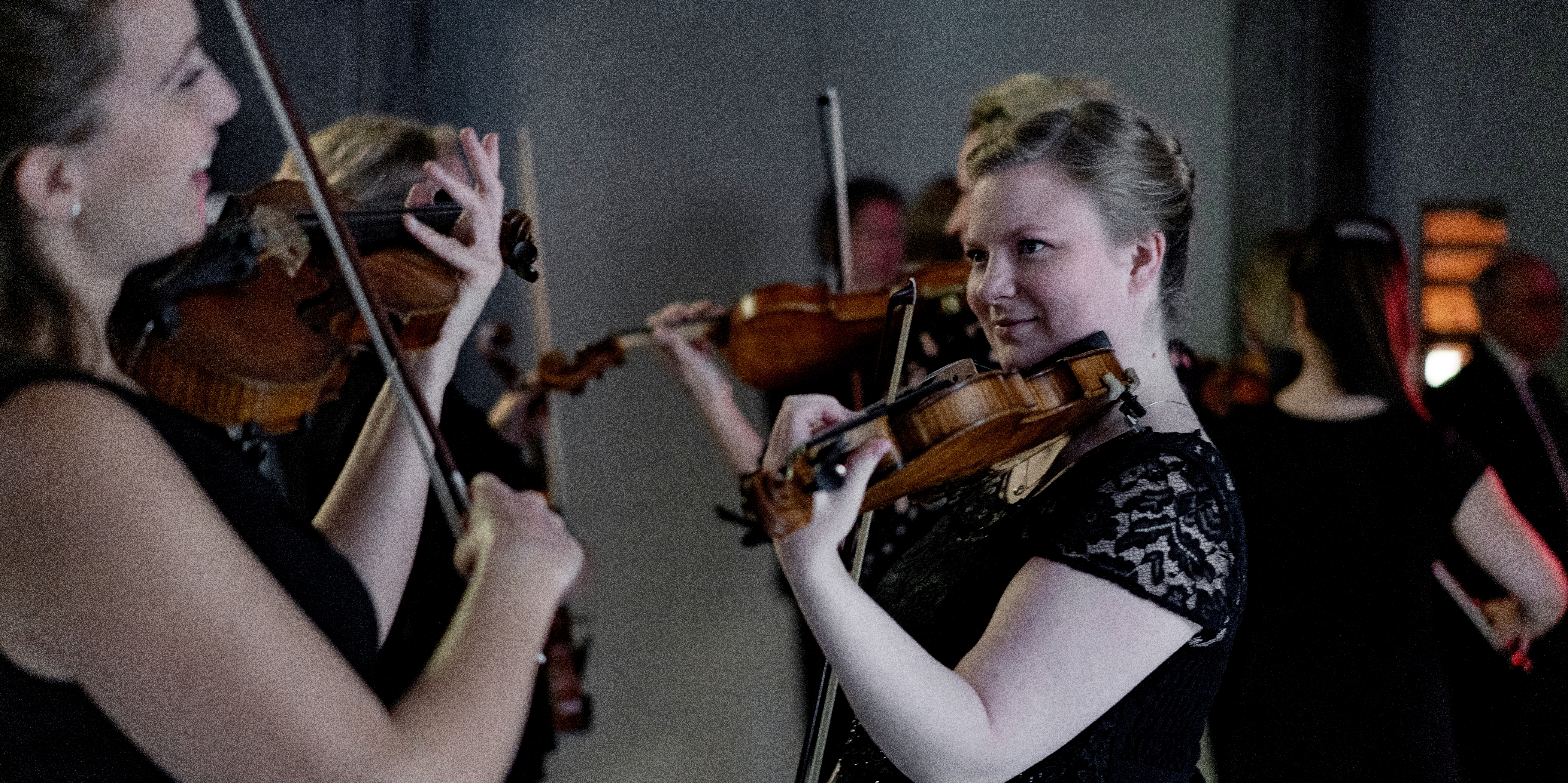 Orkester Backstage to kvinder står og spiller violin
