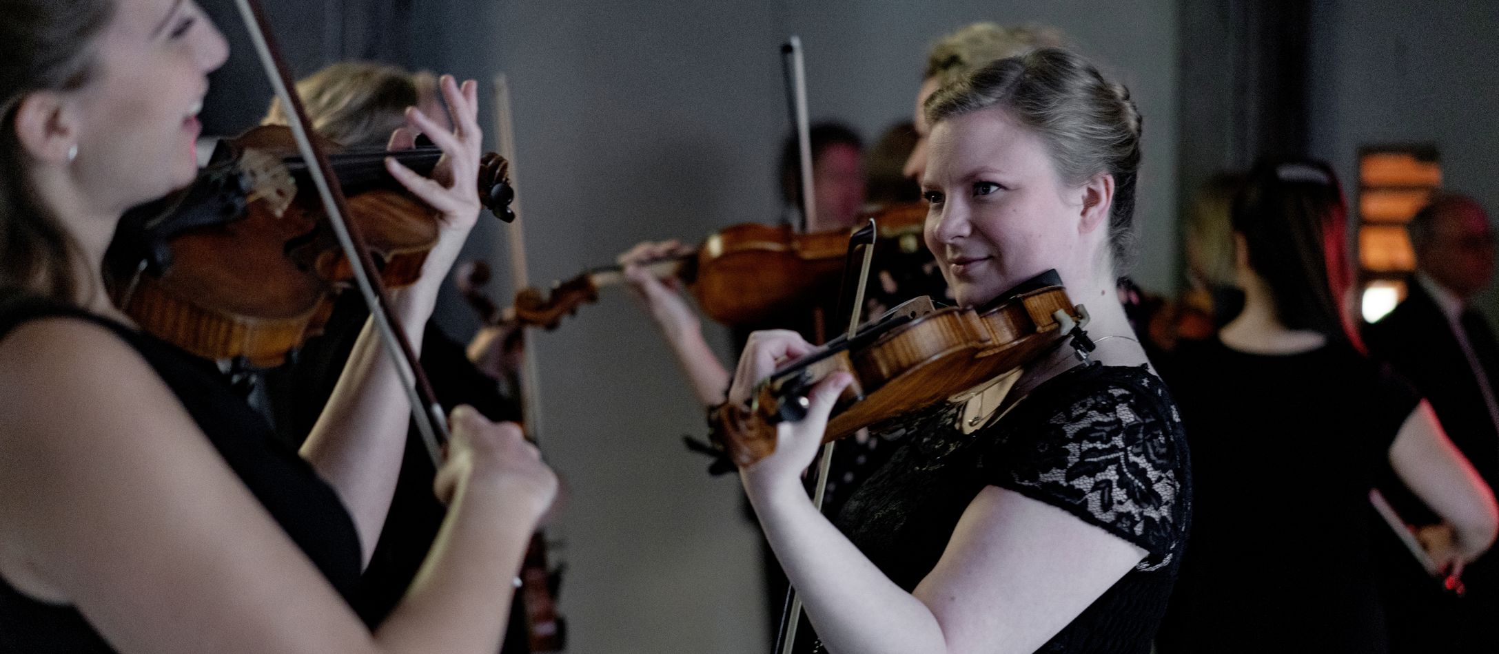 Orkester Backstage to kvinder står og spiller violin
