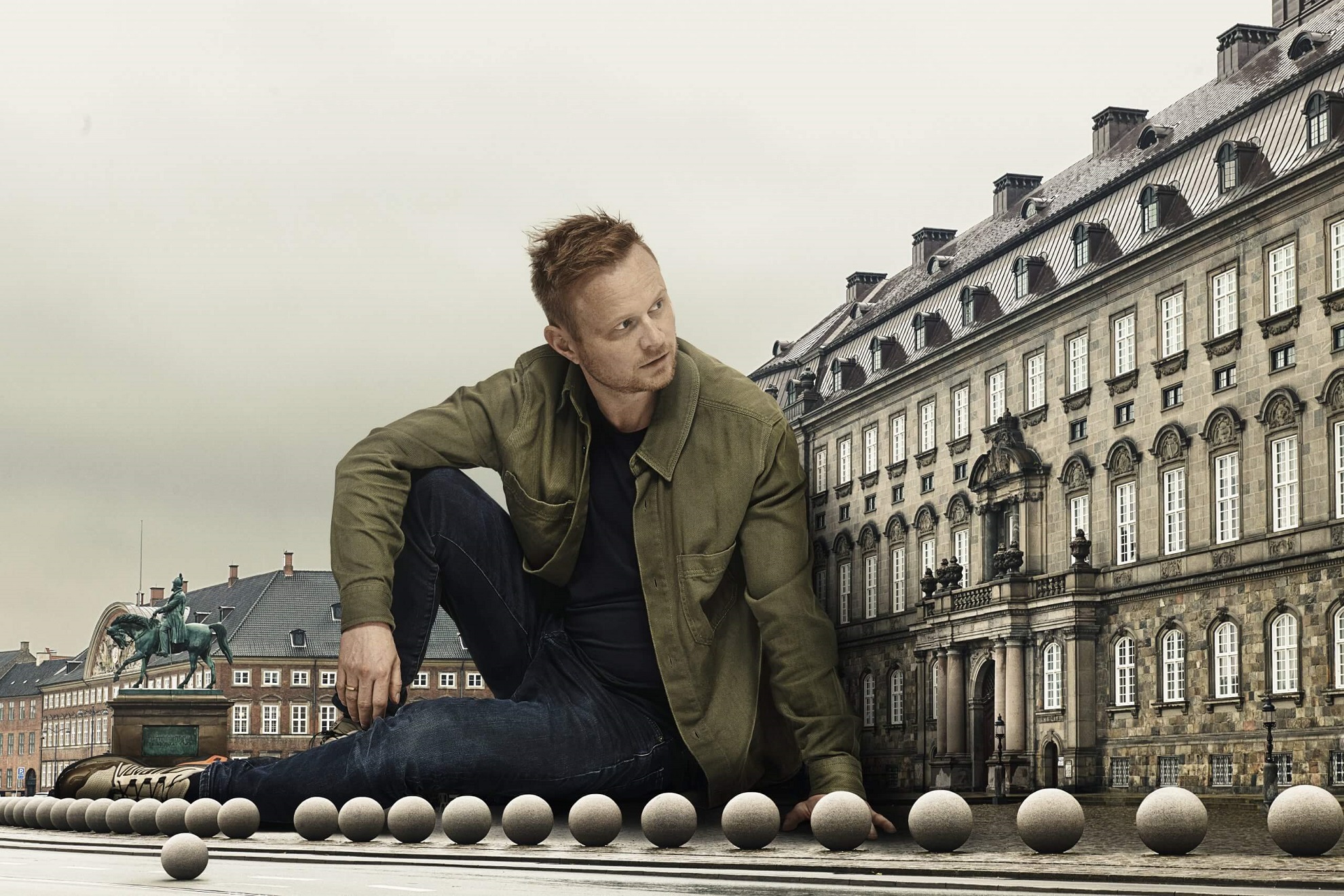 Siddende Jonathan Spang kigger mød sin venstre side foran Amalienborg