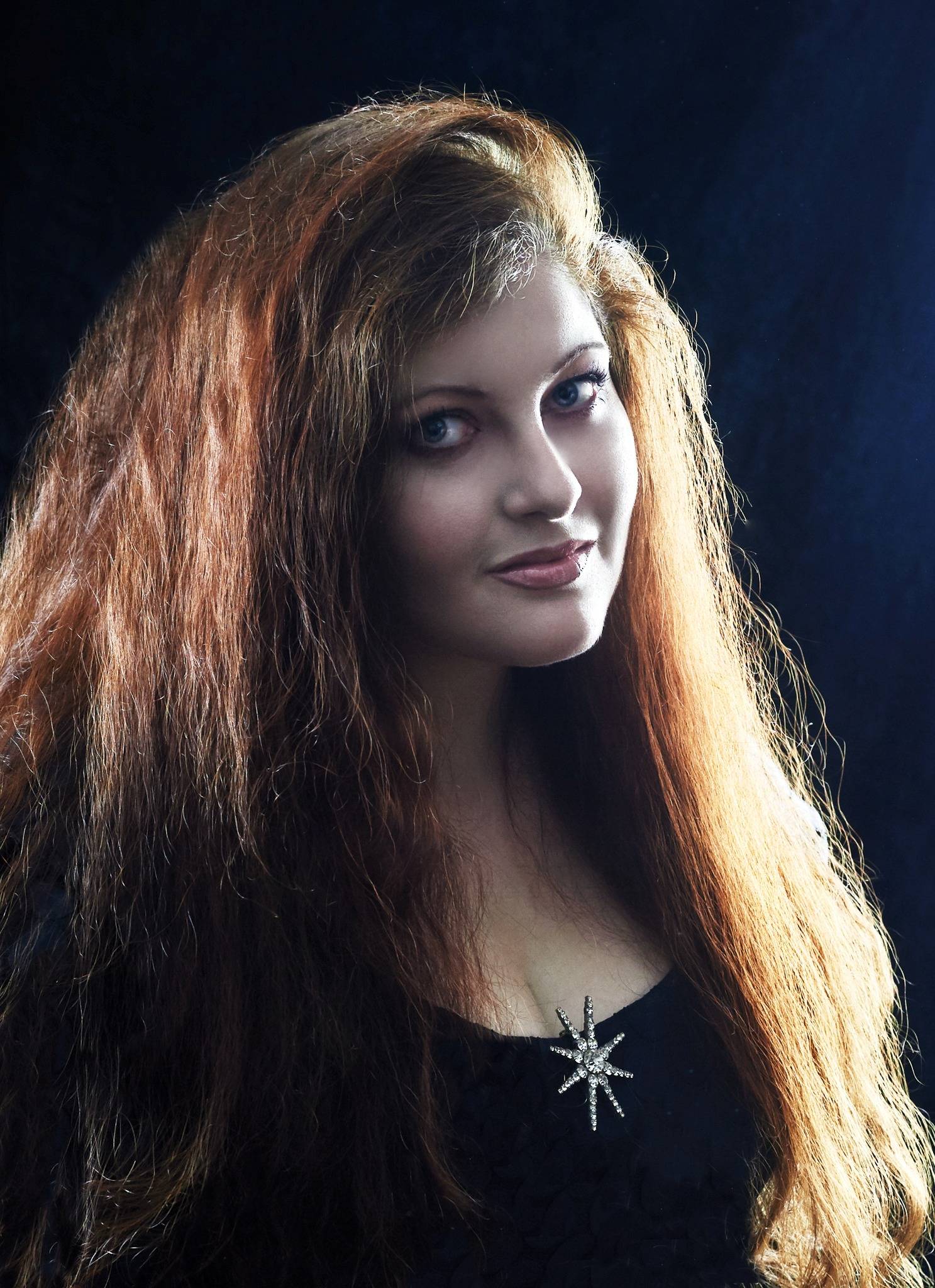 Maria Schellenberg med rødbrunt kruset hår kigger mod kameraet