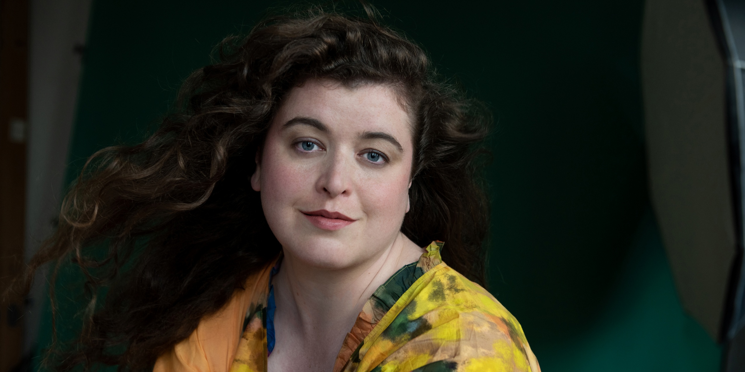 Kvinde i gul batik bluse med mørkegrøn baggrund