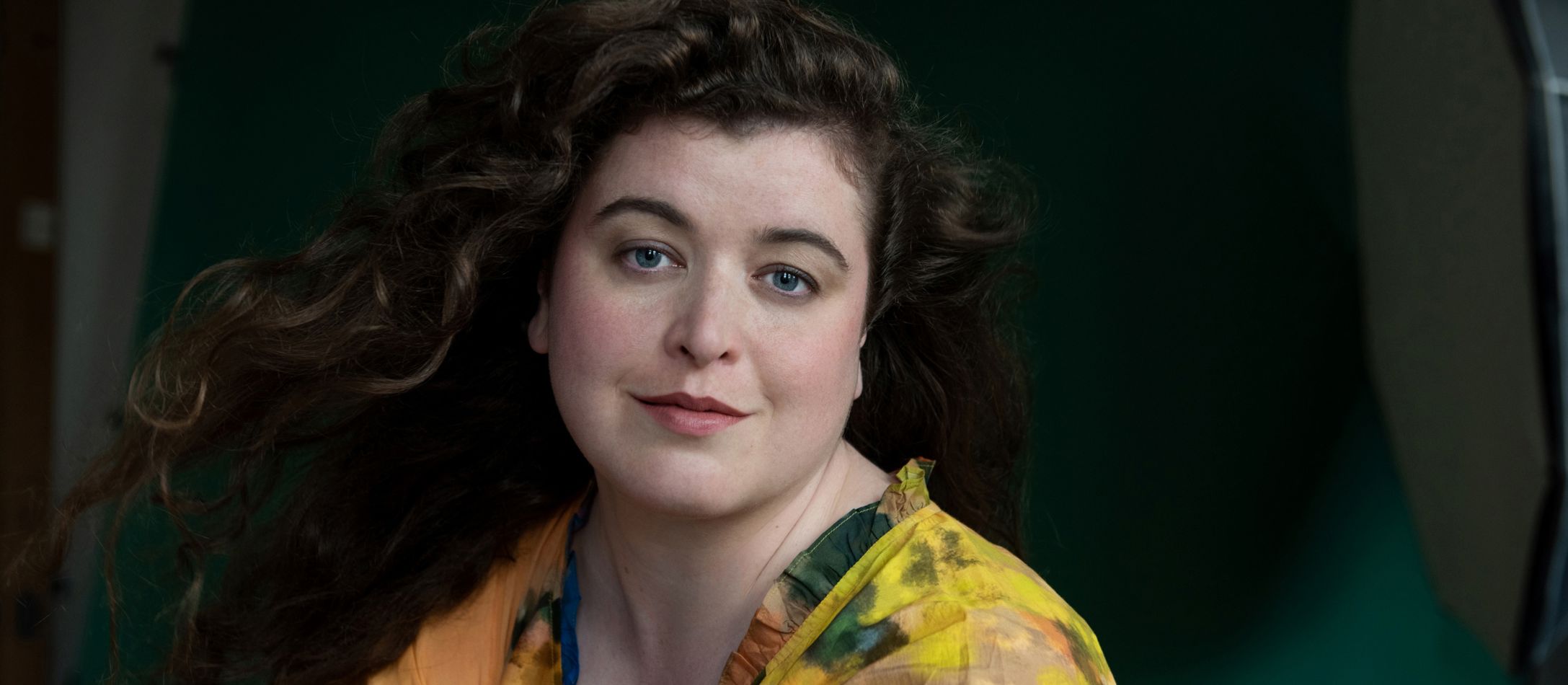 Kvinde i gul batik bluse med mørkegrøn baggrund