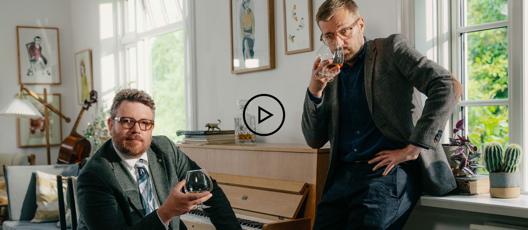 Video logo - Frederik Cilius sidder og Rasmus Bruun står ved klaveret og drikker whiskey