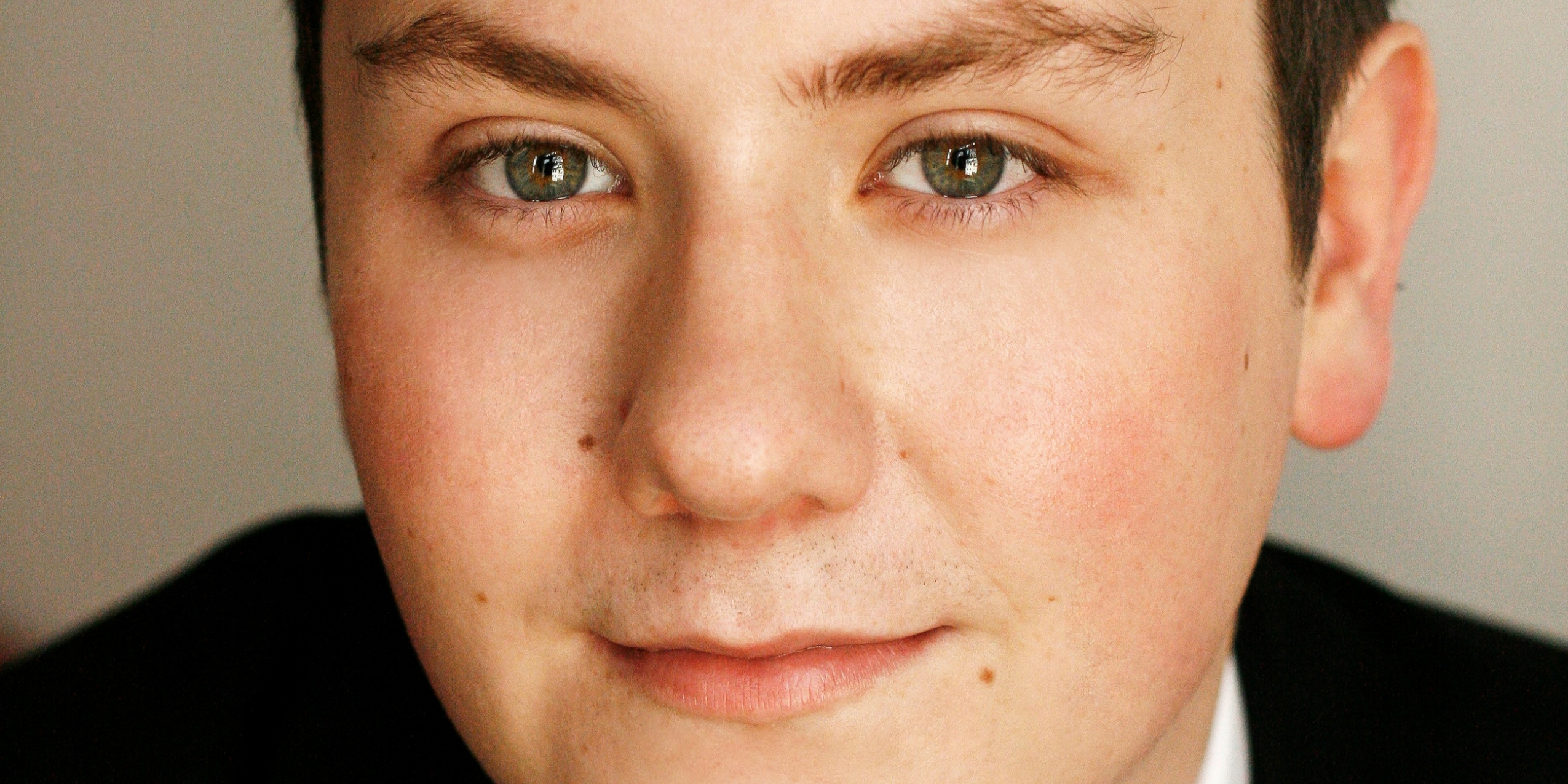 Mand i sort kigger ind i kameraet.