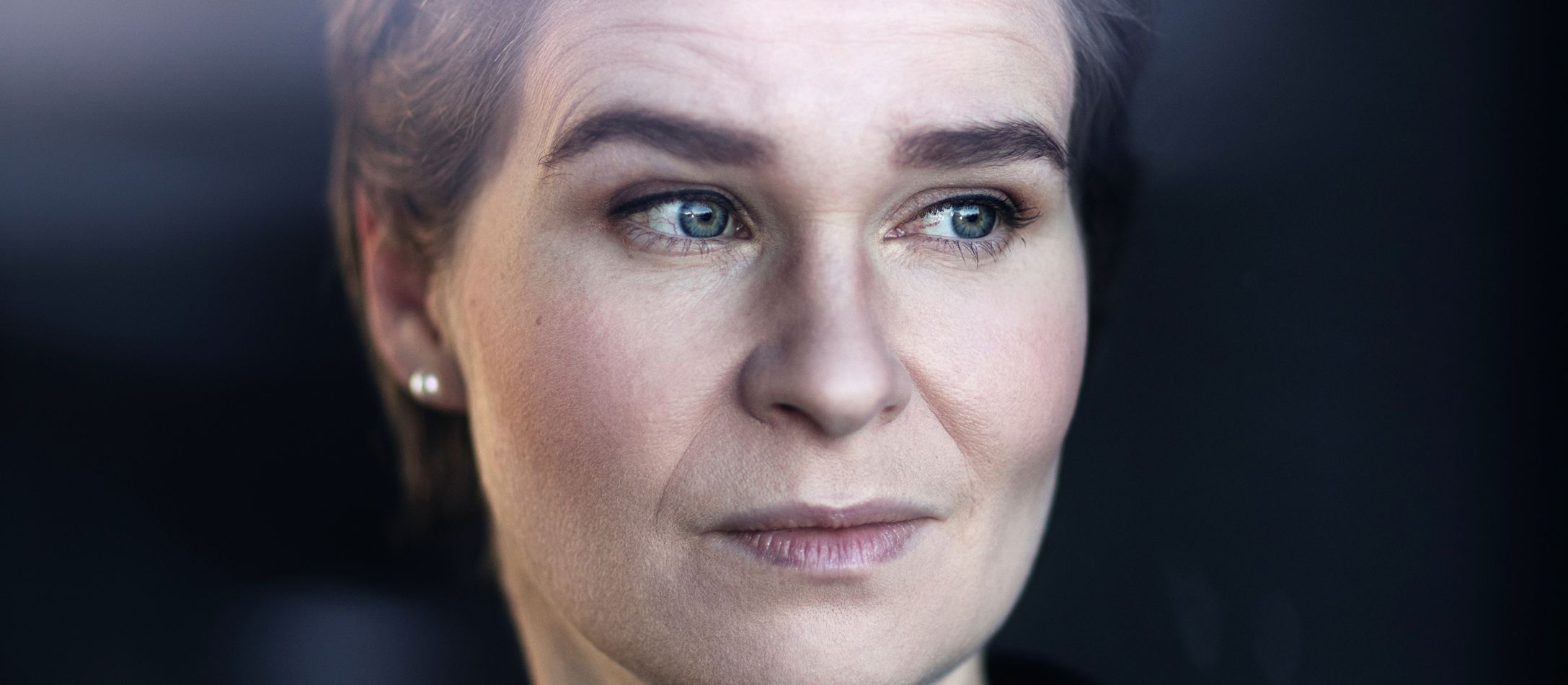 Kvinde der kigger til siden med mørk baggrund