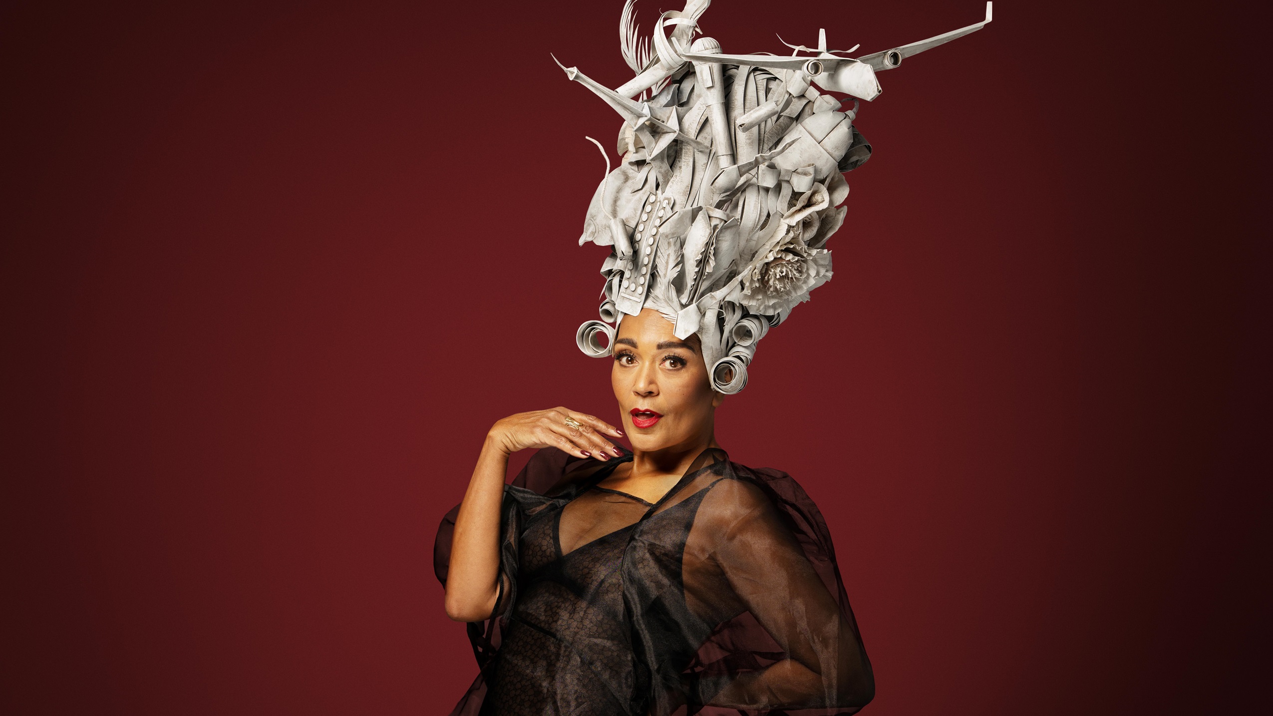 Caroline Henderson foran mørkerød baggrund med sølvfarvet hovedbeklædning ifbm. hendes koncert i DR Koncerthuset. 