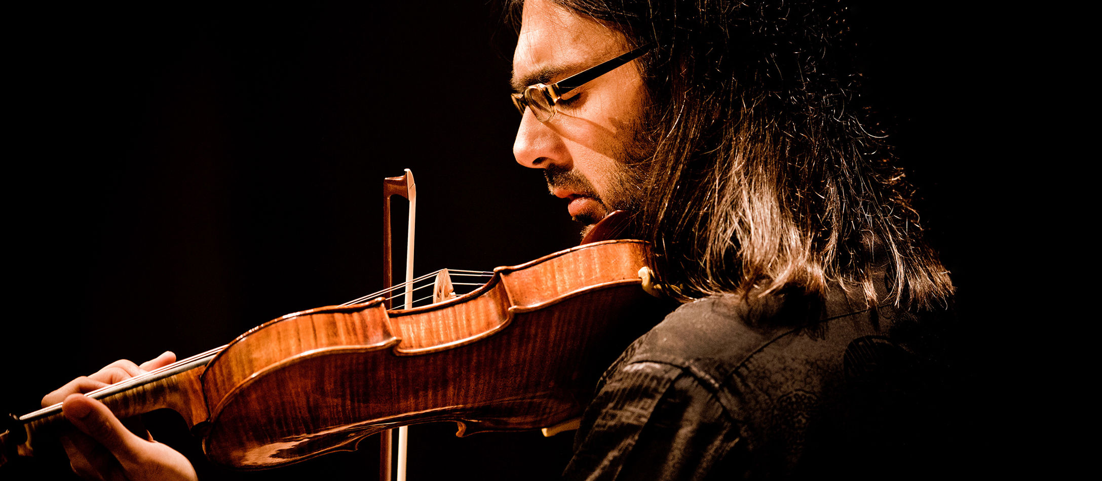 Leonidas Kavakos i profil med violin hvilende på kind til koncert i DR Koncerthuset.