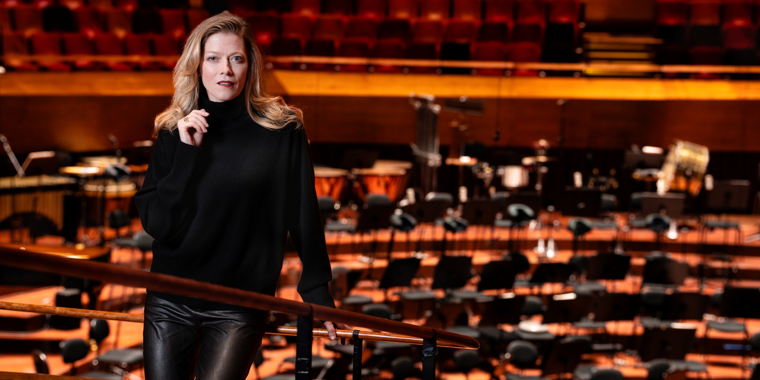 Kvinde i sort står i koncertsalen foran scenen.