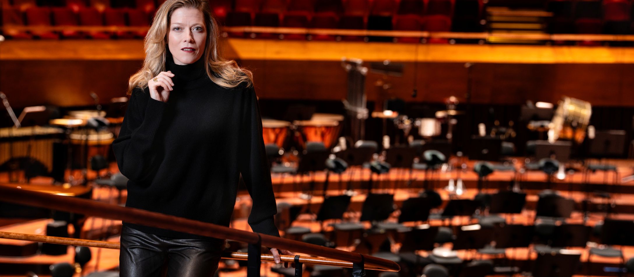 Kvinde i sort står i koncertsalen foran scenen.