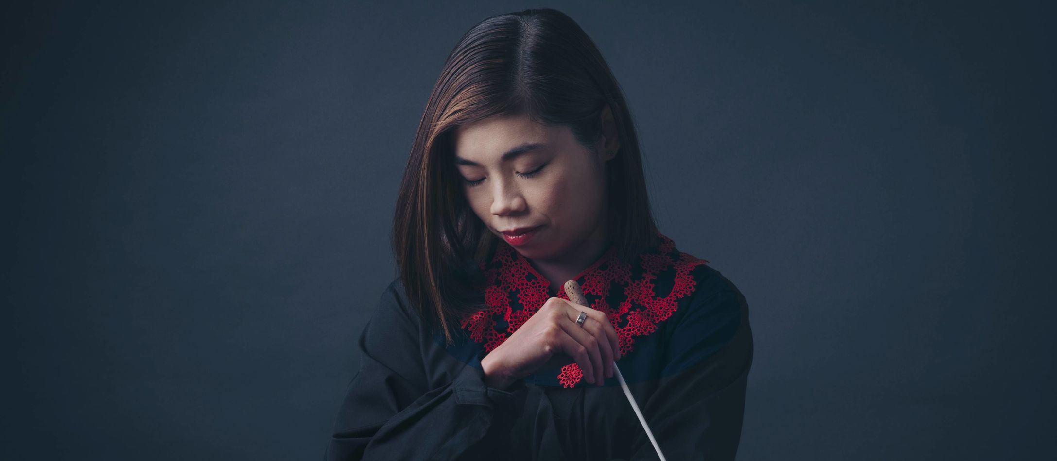 Elim Chan med dirigentstav ansigtet vendt nedad.